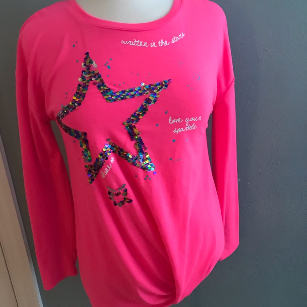 A pink shirt with a sequenced star.